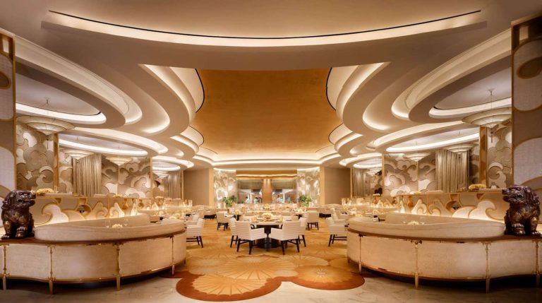 Upscale restaurant interior featuring elegant décor, sculpted ceiling lighting, and sophisticated dining seating arrangements.